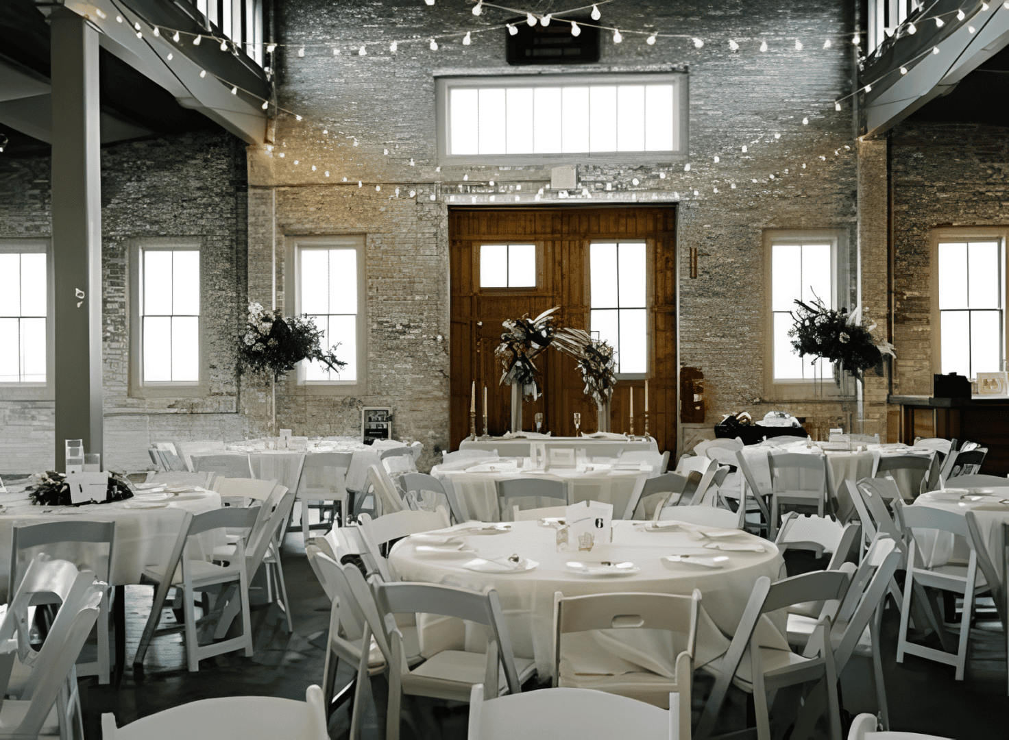 Elegant event venue with round tables and lights.